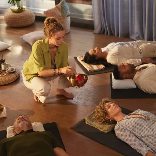 sound healing woman playing on instrument to people